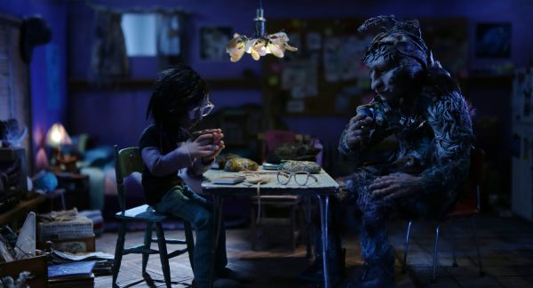 Biidaaban, a gender non conforming Anishinaabe young person drinks tea with Sabe around a kitchen table in their apartment.