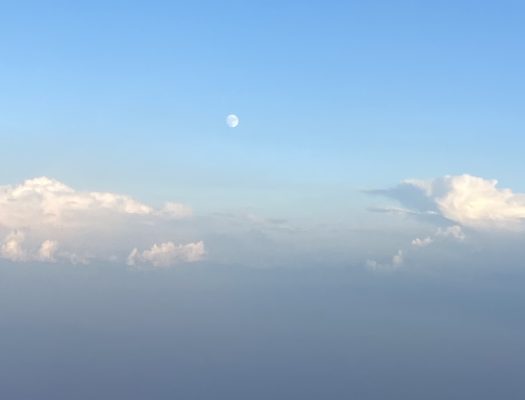 an image of the moon and some clouds in a blue sky, taken from high above the ground