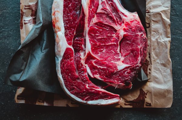 a raw cut of meat on top of two sheets of butcher wrapping paper