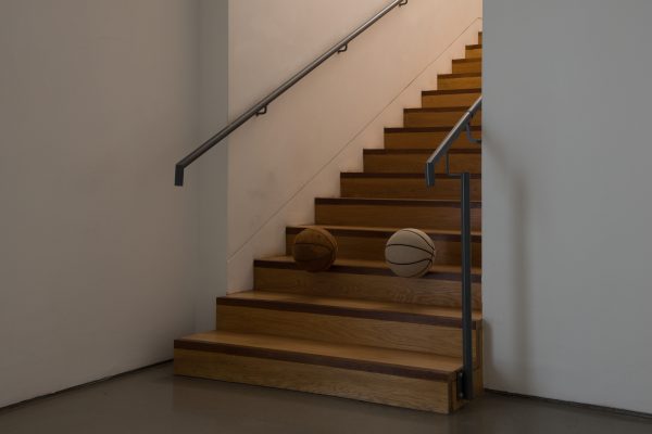 two basketballs perched on a staircase.
